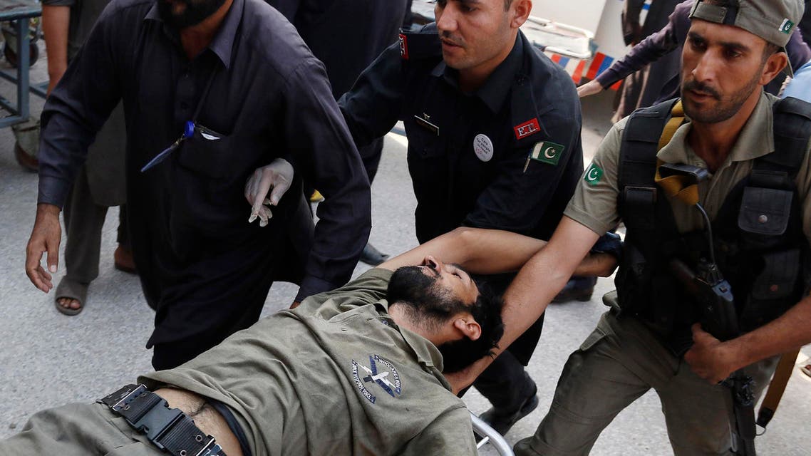 Pakistani security officials rush their colleague to a local hospital, Friday, Sept. 18, 2015 in Peshawar, Pakistan after the Taliban launched a brazen assault on a military base on the outskirts of the northwestern city, storming a mosque inside the sprawling compound and killing many worshippers during prayers. (AP Photo/Mohammad Sajjad)
