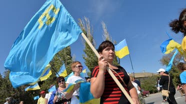  Activists hold Ukrainian and Crimean Tatar flags as they block the road at the checkpoint between Ukraine and Crimea, in Chongar, on September 20, 2015.  AP