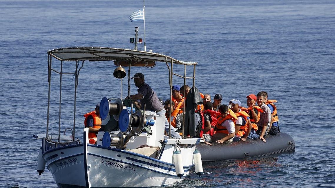 A Greek fisherman tows a dinghy overcrowded with Syrian refugees after its engine broke off the Greek island of Lesbos while crossing a part of the Aegean Sea from the Turkish coast September 19, 2015. REUTERS/Yannis Behrakis