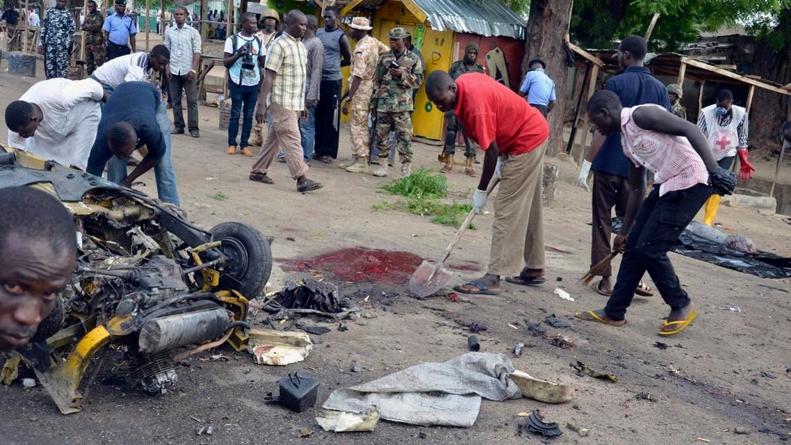 People clear up at the site of a bomb explosion, in Maiduguri, Nigeria, Friday, July 31, 2015. ap
