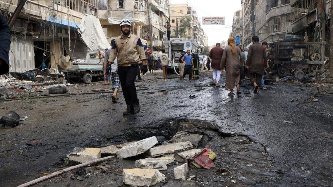 Syrian rescue workers, firefighters and citizens walk on a street following reported bombings by government forces on a market on the rebel held al-Shaar district of the northern Syrian city of Aleppo on September 21, 2015. AFP PHOTO / FADI AL-HALABI