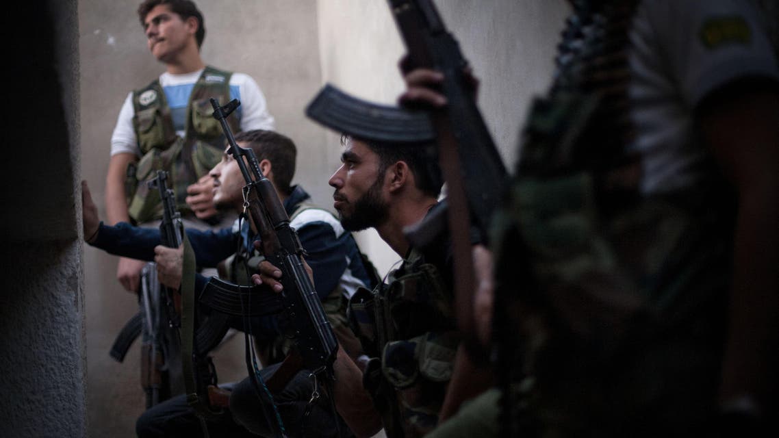 FSA fighters take cover from incoming Syrian Army fire in the Izaa district in Aleppo, Syria, Wednesday, Sept. 12, 2012. (AP Photo/ Manu Brabo)