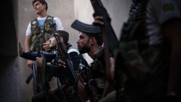  FSA fighters take cover from incoming Syrian Army fire in the Izaa district in Aleppo, Syria, Wednesday, Sept. 12, 2012. (AP Photo/ Manu Brabo)