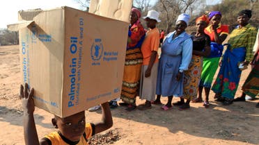  A young boy carries a box with items distributed by the United Nations World Food Programme (WFP) in Mwenezi, about 450 kilometers (280 miles) south of Harare, Zimbabwe, Wednesday, Sept. 9 2015. According to the United Nations and the Zimbabwean government some about 1.5 million people face severe food shortages due to a consecutive bad harvests and poor rains. (AP Photo/Tsvangirayi Mukwazhi)