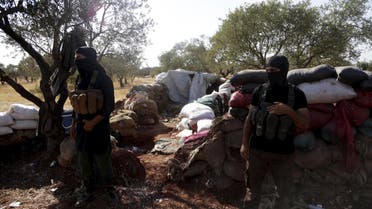 Members of al Qaeda's Nusra Front stand in front of piled sandbags near the two Shi'ite Muslim towns of al-Foua and Kefraya in northwestern Syria, September 22, 2015. Warring parties have agreed to extend ceasefires in two Shi'ite Muslim towns in northwestern Syria and another settlement near the Lebanese border until a wider deal is reached, the al-Manar TV station controlled by Lebanon's Hezbollah said on Tuesday. Pro-government militia backed by Shi'ite Hezbollah have been defending the two towns - al-Foua and Kefraya - against insurgent attacks. REUTERS/Khalil Ashawi