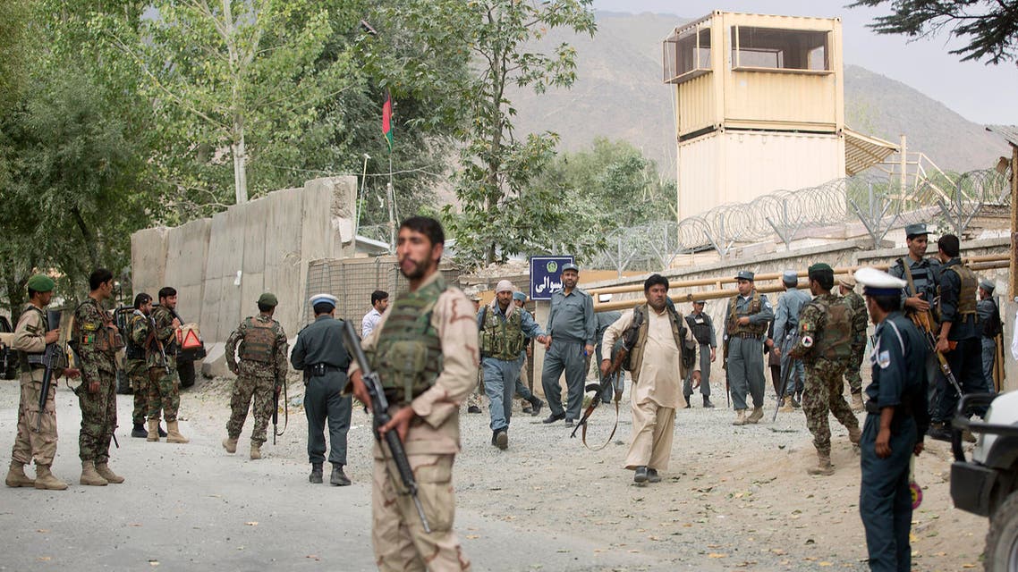 Afghan security forces gather near the main gate of Paghman district governor's compound where a suicide car bomb attack happened in Paghman district of Kabul province, Afghanistan, Wednesday, Sept. 16, 2015. The attack killed four people, including the local chief of criminal investigations, in the Paghman district, west of the capital Kabul. (AP Photo/Ahmad Nazar)