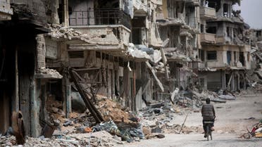  In this June 5, 2014 photo, a man rides a bicycle through a devastated part of Homs, Syria. Syrian government forces retook the control of Homs in May 2014, after a three year battle with rebels. (AP Photo/Dusan Vranic)