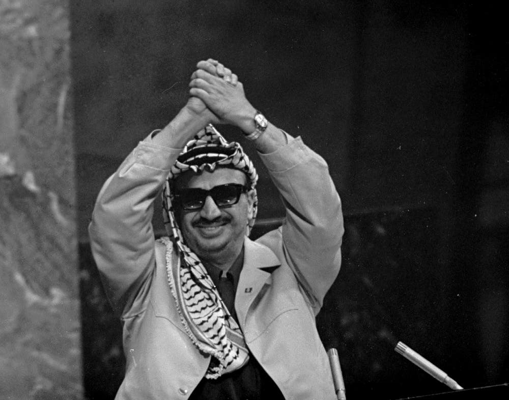 In this Nov. 13, 1974 file photo, Palestine Liberation Organization leader Yasser Arafat clasps his arms over his head as he addresses the United Nations General Assembly. ‘I have come bearing an olive branch and a freedom fighter's gun,’ he said. ‘Do not let the olive branch fall from my hands.’
