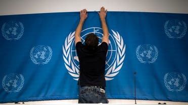  A worker sets up a United Nations banner at the media center in preparations for the start of this week's Syria peace talks in Montreux and Geneva, in Montreux, Switzerland, Tuesday, Jan. 21, 2014. Russia and Iran on Tuesday criticized the U.N. chief’s decision to withdraw Tehran’s invitation to join the peace conference on Syria, as diplomats said a new report on Syrian regime atrocities underscored the urgent need to try to end the country’s brutal civil war. (AP Photo/Anja Niedringhaus)