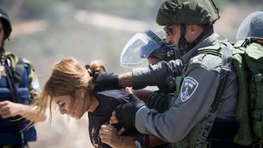 An Israeli border police officer detains a Palestinian woman during a protest against the expansion of the nearby Jewish settlement of Halamish, in the West Bank village of Nabi Saleh near Ramallah. (File photo: AP)