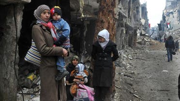 In this Feb. 4, 2014, file photo released by the Syrian official news agency SANA, residents of the besieged Yarmouk Palestinian refugee camp wait to leave the camp on the southern edge of the Syrian capital Damascus. (AP)