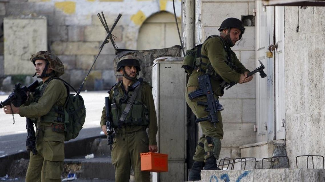 An Israeli army soldier breaks a building's lock to get to the roof during clashes with Palestinians over tension in Jerusalem's al-Aqsa mosque, in the occupied West Bank city of Hebron September 29, 2015. REUTERS