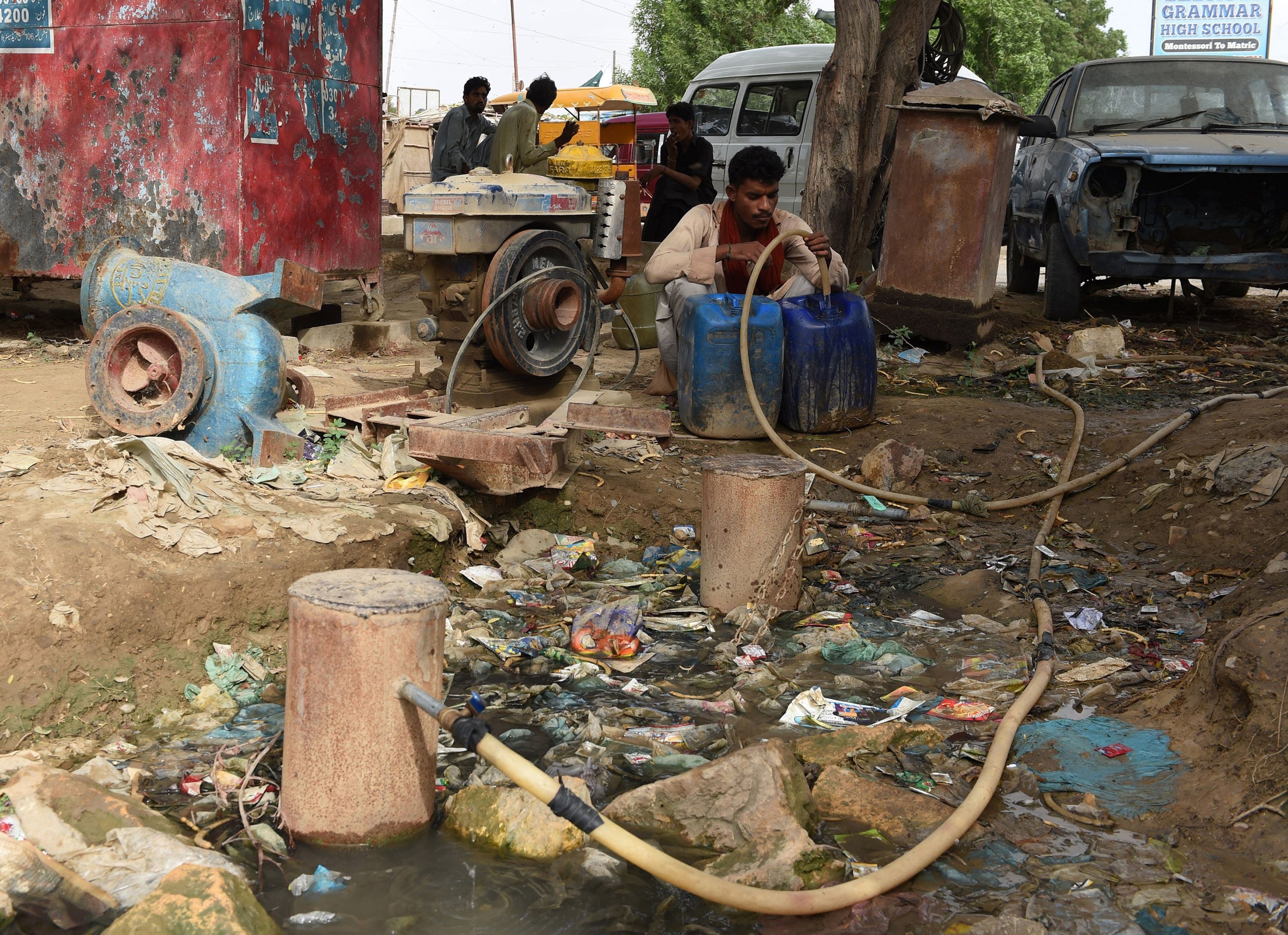 In this photograph taken on August 20, 2015, a Pakistani man fills a container with water in a slum area of Karachi.
