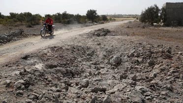 A man rides a motrobike past a site hit overnight by what activists aid were airstrikes carried out by Russian air force near a camp for displaced people on the outskirts of al-Ghadfa town in the southern countryside of Idlib, Syria. (File: Reuters)