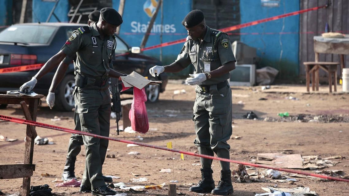 Police bomb squad personnel gather debris for analysis at the scene of a bomb blast in Nyanya, on the outskirts of Abuja. (Reuters)