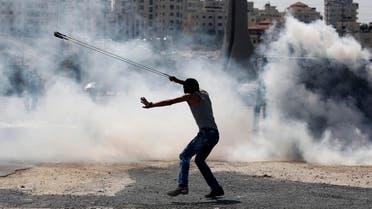 A Palestinian demonstrator uses a slingshot during clashes following a demonstration in the West Bank city of Ramallah. (AP)