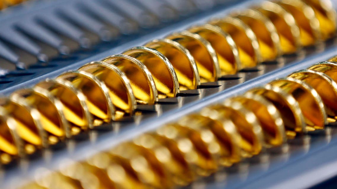Blank coins are lined up before being stamped at the U.S. Mint at West Point on Tuesday, July 22, 2014, in West Point, N.Y. President John F. Kennedy is getting a new look on a new gold coin that is being made by the mint to mark the 50 years since the slain president debuted on a half-dollar. (AP Photo)