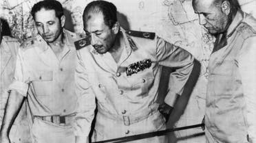 Egyptian President Anwar al-Sadat is flanked by officials as he reviews maps of battle development in the desert of Sinai Peninsula, at his Army headquarters in Cairo, on October 15, 1973 (AP)