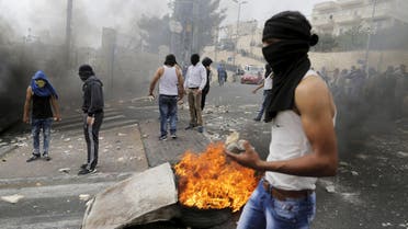 A masked Palestinian holds stones during clashes with Israeli police in Sur Baher, a village in the suburbs of Arab east Jerusalem, October 7, 2015. A suspected Palestinian militant stabbed and wounded an Israeli soldier, snatched his gun and was then shot dead by special forces on Wednesday, police said, as a surge of violence prompted Israel's prime minister to cancel a visit to Germany. Hours earlier, police said an 18-year-old Palestinian woman stabbed an Israeli near a contested shrine in Jerusalem, and was then shot and wounded by the injured man, the third knife attack in the city in less than a week. REUTERS/Ammar Awad
