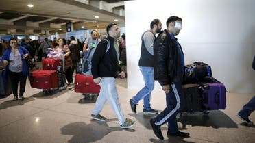 Christian Syrian refugee Walid Aleid (R), injured in a September bomb attack in Damascus, arrives with fifteen family members at the Charles-de-Gaulle Airport in Roissy from Beirut, October 2, 2015. A Syrian Christian family targeted by a September bomb attack in Damascus flew into Paris on Friday to start a new life, roughly a year after they requested entry visas from the French authorities. REUTERS/Stephane Mahe