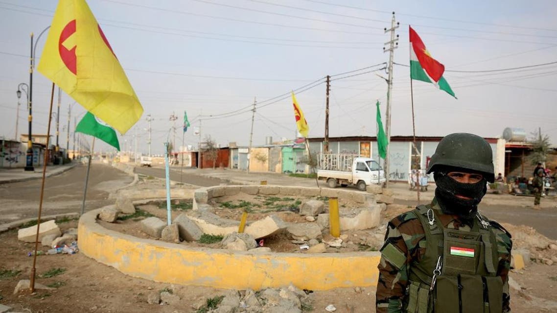 In this Jan. 29, 2015 file photo, a Kurdish peshmerga soldier of the Kurdish KDP party poses in front of KDP and PUK flags in the town of Snuny, close to Sinjar, northern Iraq. (AP)