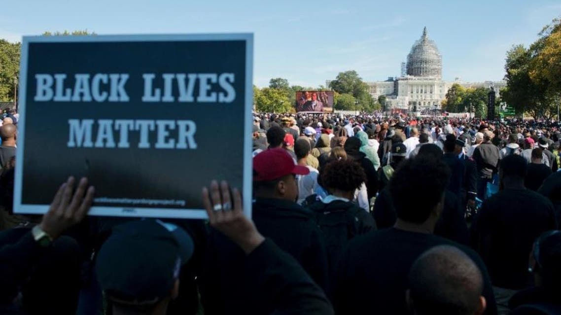 People listen to speeches during the Justice or Else! rally on the National Mall in Washington, DC on October 10, 2015 (AFP)