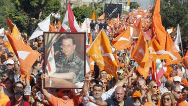 Supporters of the Free Patriotic Movement (FPM) carry flags and a picture of Christian politician and FPM founder Michel Aoun during a rally to show support for him and to mark the October 13 anniversary, near the presidential palace in Baabda, near Beirut, Lebanon October 11, 2015. Thousands of Lebanese rallied near the presidential palace on Sunday in a show of support for Christian politician Michel Aoun, pressing their demand for him to fill the vacant presidency. The rally was called to mark events in October 1990, near the end of the Lebanese civil war, when the Syrian army captured Baabda. Aoun - head of one of two rival administrations at the time - was forced out of the presidential palace and later into exile. REUTERS/Mohamed Azakir