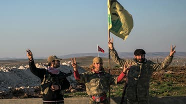 In this Sunday, Feb. 22, 2015, file photo, Syrian Kurdish militia members of YPG make a V-sign next to poster of Abdullah Ocalan, jailed Kurdish rebel leader, and a Turkish army tank in the background in Esme village in Aleppo province, Syria. ap 