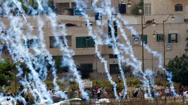 Palestinians run from tear gas fired by Israeli troops during clashes near Ramallah, West Bank, Saturday, Oct. 10, 2015. (AP)