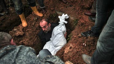 A man lowers the body of Sarigul Tuylu, 35, a mother of two that was killed in Saturday's bombing attacks in Ankara, Turkey, during her funeral in Istanbul, Sunday, Oct. 11, 2015. (Reuters)