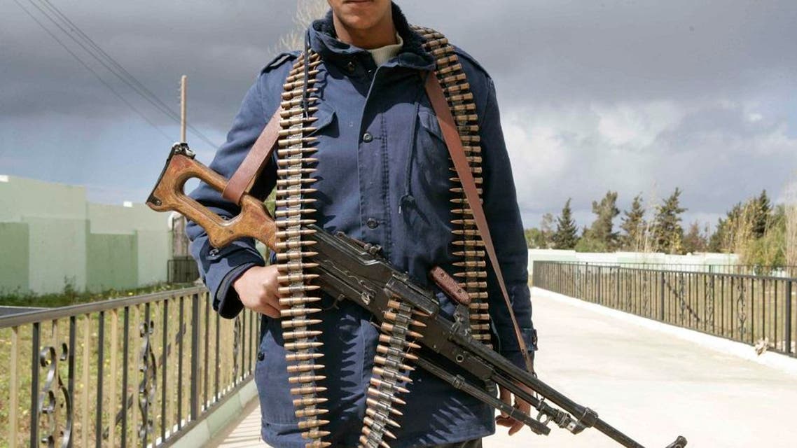 In this photo released by China's Xinhua News Agency, a man holding an automatic machine gun poses in the east Libyan city of Albayda Thursday, Feb. 24, 2011. (AP Photo/Xinhua, Nasser Nouri)