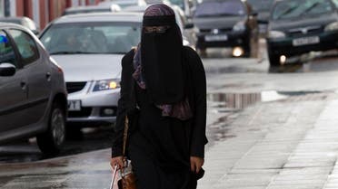 A member of the public wearing a full face veil is seen in Blackburn, England, Wednesday, Sept. 19, 2013. A judge ruled earlier this week that a female Muslim defendant may stand trial wearing a face-covering veil — but must remove it when giving evidence. The compromise ruling had some insisting it backs a woman's religious right to wear the veil, and others saying it shows British justice remains independent and won't bow to religious demands. (AP Photo/Jon Super)
