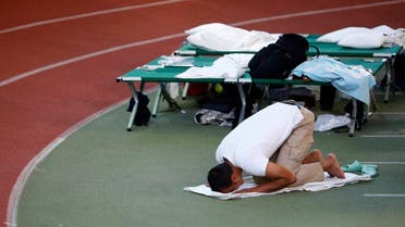 A Muslim asylum seeker prays at an temporary shelter in a sports hall in Hanau, Germany. (AP)
