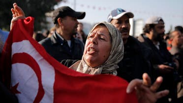 A woman holds a Tunisian national flag as she demonstrates in front of the National Bardo Museum. (AP)