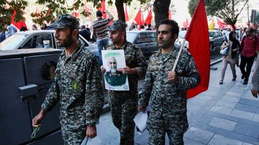 A member of the Iranian Revolutionary Guard holds a poster of Gen. Hossein Hamedani during his funeral ceremony in Tehran. (AP)