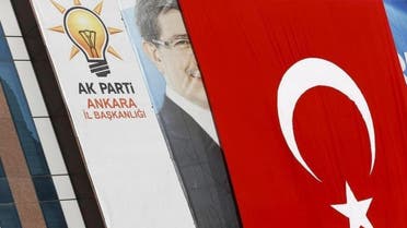 A big Turkish flag partly covers the portrait of Turkish Prime Minister Ahmet Davutoglu hung on an office of Turkey's ruling AK Party. (Reuters)