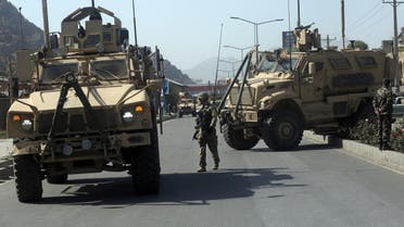 A U.S. soldier directs his colleague at the site a bomb attack that targeted several armored vehicles belonging to forces attached to the NATO Resolute Support Mission, in downtown of Kabul, Afghanistan, Sunday, Oct. 11, 2015. Gen. Abdul Rahman Rahimi, the Kabul city police chief, said that three Afghan civilians were wounded in the attack that damaged one of the vehicles but caused no fatalities. (AP Photo/Massoud Hossaini)
