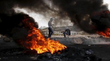 Smoke rises from burning tyres as Palestinian protesters are seen during clashes with Israeli troops near the Jewish settlement of Bet El, near the West Bank city of Ramallah. (Reuters)