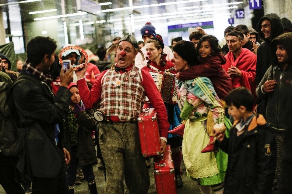 Members of the Red Nose Clown doctors perform for refugees at the main train station in Vienna, Austria