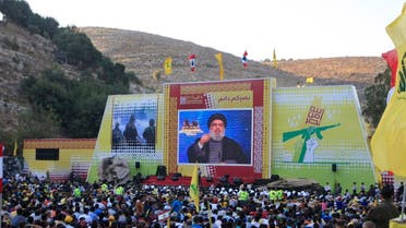 Hezbollah supporters listen to Hassan Nasrallah delivering a speech from a secret location through a giant TV screen. (File photo: AP)