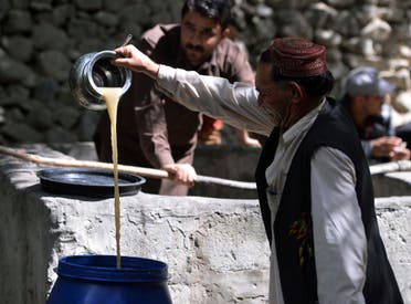 In this photograph taken on September 27, 2015, a local resident pours the juice from crushed grapes as part of a brewing wine process in a garden in the remote village of Sher Qilla in Punyal valley in northern Pakistan.