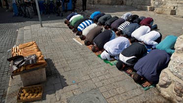  Palestinians pray as Israeli border police officers stand guard during Muslim Friday prayers outside the Al-Aqsa Mosque after Israel barred men under 45 from the mosque compound, Friday, Oct. 9, 2015. A rash of individual attacks between Palestinians and Israelis threatened to spread throughout Israel Friday as a 14-year-old Israeli and a police officer were stabbed in separate incidents while an Israeli stabbed four Arabs in the southern city of Dimona. (AP Photo/Ariel Schalit)
