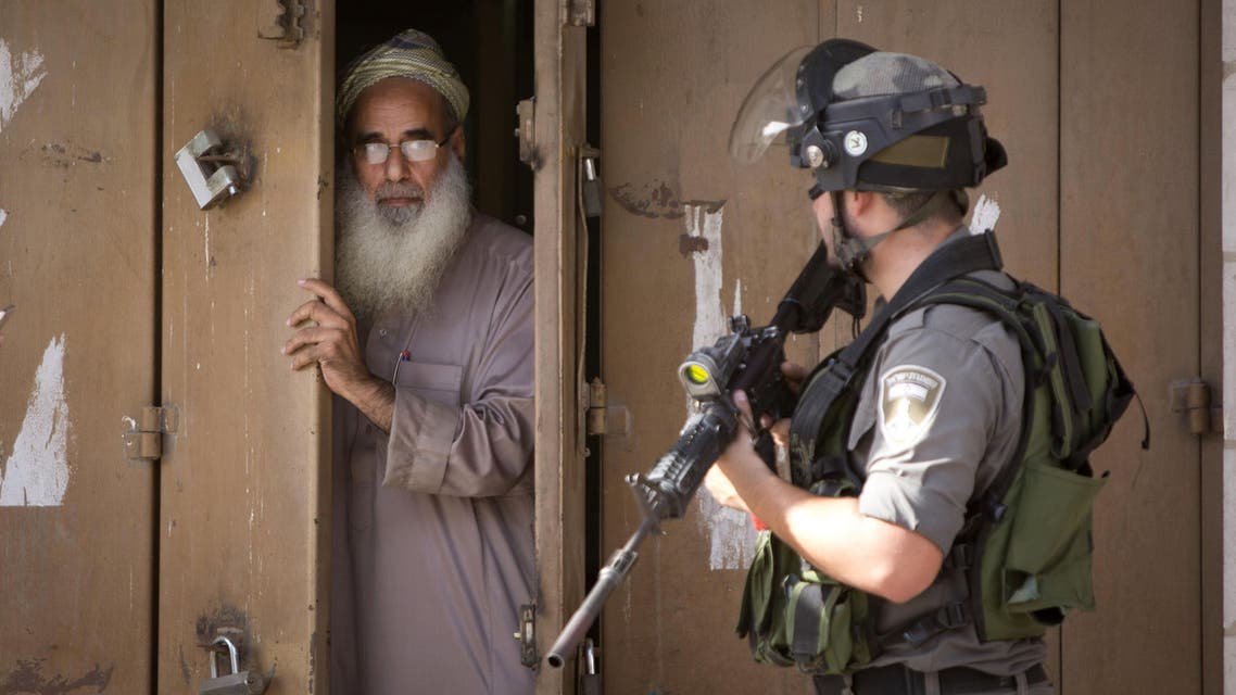 A Palestinian man closes his shop during clashes between Israeli troops and Palestinian protesters, in the West Bank town of al-Ram, north of Jerusalem, Thursday, Oct. 22, 2015. Ten Israelis have been killed over the last month, mainly in stabbing attacks. On the Palestinian side, 48 people have been killed. The violence erupted a month ago, fueled by rumors that Israel was plotting to take over a sensitive Jerusalem holy site revered by both Jews and Muslims. (AP Photo/Majdi Mohammed)