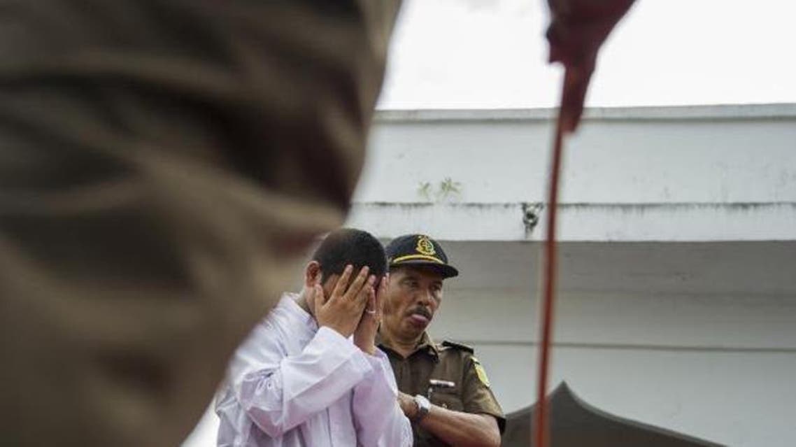 An Acehnese man convicted for "immoral acts" prepares for punishment to be administered by a hooded local government officer during a public caning at a square in Banda Aceh, Aceh province, on June 12, 2015 ©Chaideer Mahyuddin (AFP)