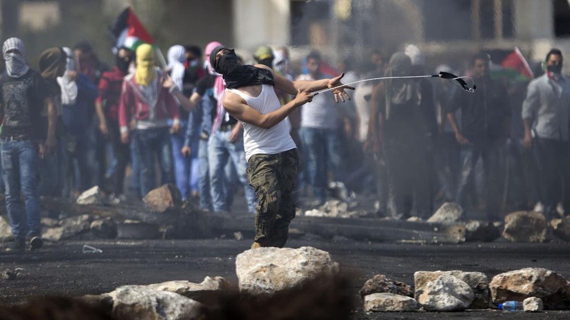 A Palestinian hurls a stone during clashes with Israeli troops, near Ramallah. (AP)