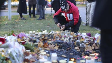 A man lights a candle outside Kronan school in Trollhattan, Sweden October 23, 2015.