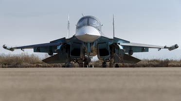 Russian ground staff members work on a Sukhoi Su-34 fighter jet at the Hmeymim air base near Latakia, Syria. (Reuters)