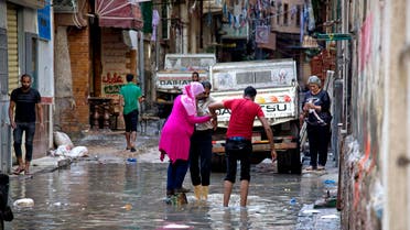 Egyptians walk through water after a heavy rainfall in the coastal city of Alexandria, Egypt, Sunday, Oct. 25, 2015. (AP)