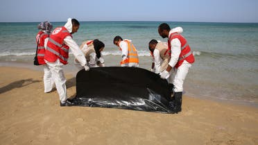  Red Crescent workers prepare to carry the lifeless body of a migrant, off the shore of Gasr Garabulli, in the eastern city of Tripoli, Libya, Wednesday, Oct. 21, 2015. Red Crescent collected the bodies of six people including an infant. (AP Photo/Mohamed Ben Khalifa)