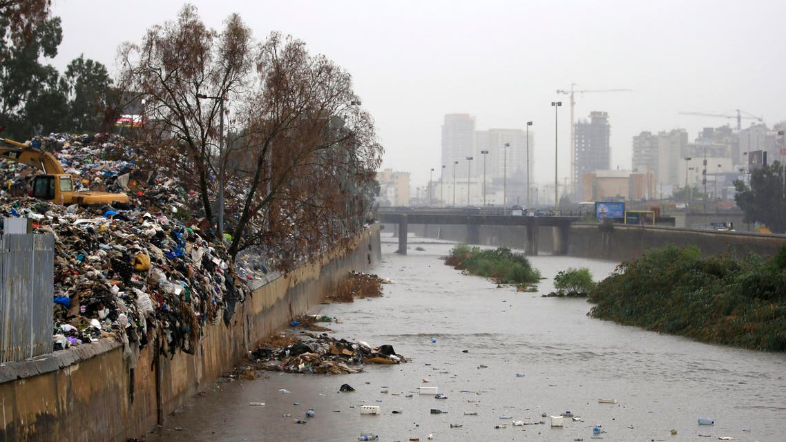 A pile of garbage, left, lies on the bank as trash floats on the Beirut River, in Karantina, east Beirut, Lebanon, Sunday, Oct. 25, 2015. Early heavy showers Sunday in Lebanon’s capital Beirut compounded the city’s trash problem, as trash pilling in the streets and along river banks started flowing with the rain water, raising a public health scare. The Beirut river, where garbage has piled on the banks, was also flooded with trash and activists volunteered to clean it, reinvigorating the anti-government activist campaign. (AP Photo/Hassan Ammar)